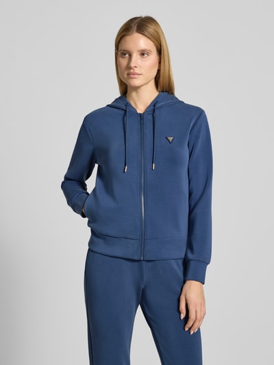 Vrouwenmodel draagt Regular Fit Sweatshirt met logo-applicatie model 'Olympe' van Guess Activewear, elastische materiaal-mix met modal, kap met trekkoord, ritssluiting, elastische boorden, donkerblauw, voorkant hele lichaam
