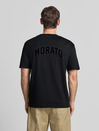 Männermodel trägt Relaxed Fit T-Shirt aus puur katoen van Antony Morato in zwart met labelpatch, ruglengte maat M 70 cm, Ganzkörperansicht Rückansicht.