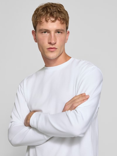 Männermodel trägt weißes Relaxed Fit Langarmshirt aus Baumwoll-Mix Modell 'SCASPIAN' von ONLY, Herren T-Shirt, Nahaufnahme Oberkörper.