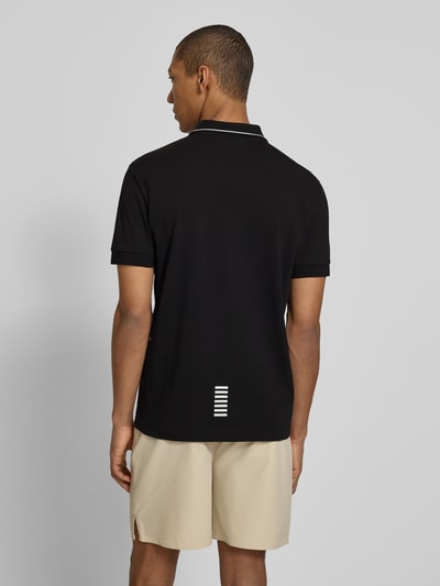 Männermodel trägt Regular Fit Poloshirt mit Logo-Print von EA7 Emporio Armani in Schwarz, Baumwoll-Mix, Rückansicht Ganzkörperansicht.