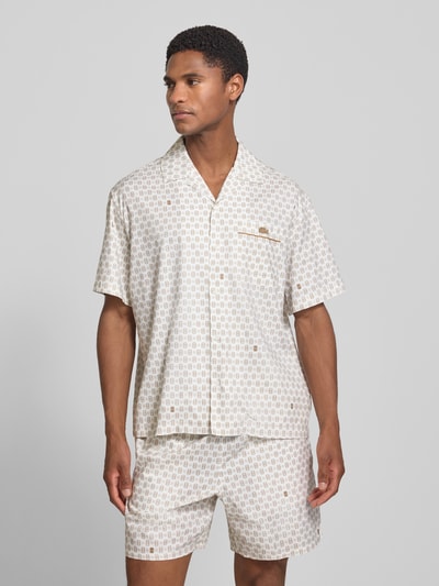 Mannenmodel draagt relaxed fit heren vrijetijdsoverhemd model 'Tennisco' van katoenmix van Lacoste in lichte tinten met fijn patroon, geheellichaamsopname vooraan.