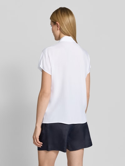 Frauenmodel trägt Regular Fit Bluse aus Viskose von Christian Berg Woman in Weiß mit Hemdblusenkragen und Knopfleiste, Rückenlänge 64 cm, Ärmellänge 15 cm, Ganzkörperansicht Rückansicht.