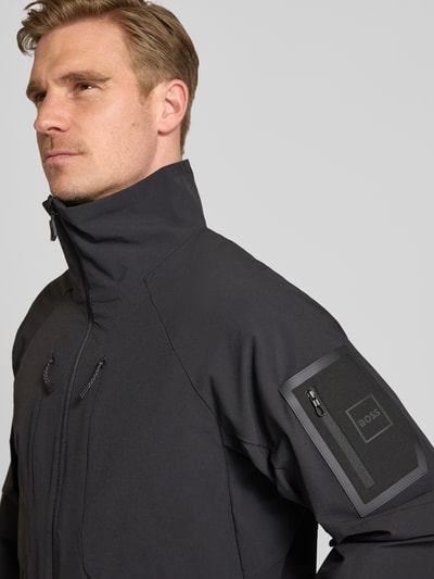 Männermodel trägt Regular Fit Trainingsjacke mit Label Patch Modell 'OW_GLOBE' von BOSS Green, Optik: Unifarben, Nahaufnahme Oberkörper.