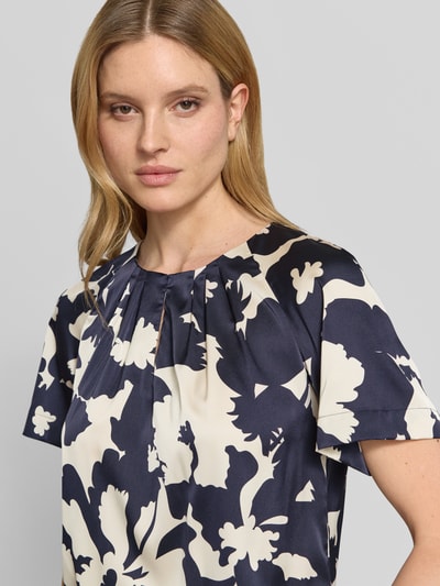 Frauenmodel trägt Blusenshirt im Allover-Look von Comma, Material-Mix mit Stretch-Anteil, Regular-Fit, Schlüsselloch-Ausschnitt, Nahaufnahme Oberkörper.