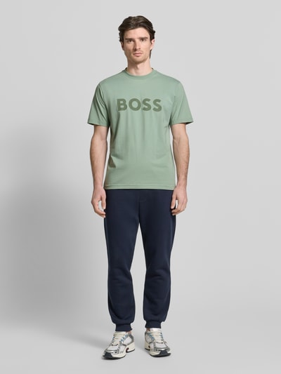 Männermodel trägt Regular Fit T-Shirt aus Baumwoll-Mix Modell 'ICONIC' von BOSS Green in Mintgrün, Rundhals, Ganzkörperansicht von vorne.