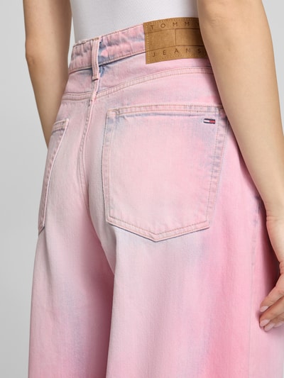 Frauenmodel trägt Loose Fit Jeans aus Baumwoll-Mix Modell 'CHARLIE MR LOOSE' von Tommy Jeans, rosa unifarben, Logo Stitching, 5-Pocket, Nahaufnahme Rückansicht.