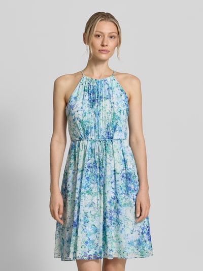 Frauenmodel trägt Minikleid in Falten-Optik mit floralem Allover-Print von Jake*s Cocktail, taillierte Passform, abnehmbares Stoffband, ärmelloses Design, Farben in Blau und Grün, feine Textur, Ganzkörperansicht von vorne. Rückenlänge bei Größe 36: 87 cm, Brustweite: 35 cm.