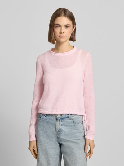 Modelka nosi różowy Rundhals Pullover mit Tunnelzug od Review, luźny krój, ściągacze, długość 52 cm, długość rękawa 62 cm, widok z przodu.
