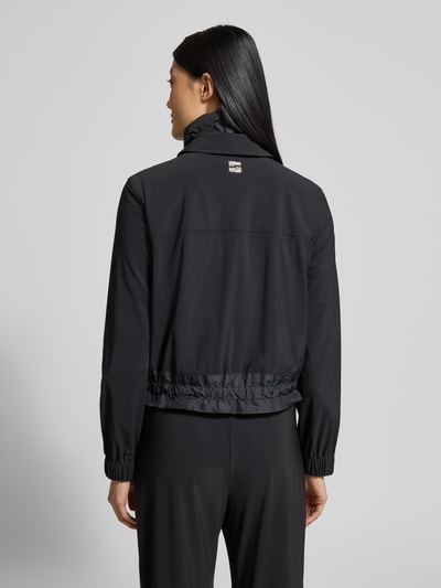 Männermodel trägt Blazer mit Stehkragen von Marc Cain w kolorze czarnym, materiał z domieszką stretchu, długość do bioder, widok z tyłu, Ganzkörperansicht Rückansicht.