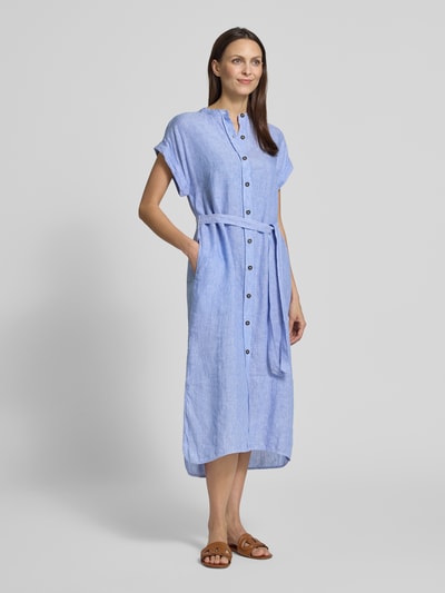 Frauenmodel trägt Hemdblusenkleid aus Leinen mit Bindegürtel Modell 'AMATISTA' von ECOALF in Hellblau, lockerer Schnitt, Knopfleiste, Ganzkörperansicht von vorne.