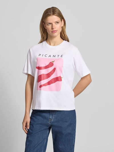 Frauenmodel trägt T-Shirt mit Statement-Print Modell 'SENNA' von JJXX, weiß mit rotem Print, reine Baumwolle, lockere Passform, Ganzkörperansicht von vorne.