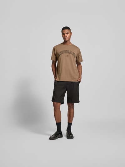 Männermodel trägt Regular Fit T-Shirt mit Logo-Print von MM6 Maison Margiela, Herren T-Shirt aus reiner Baumwolle, Ganzkörperansicht von vorne.