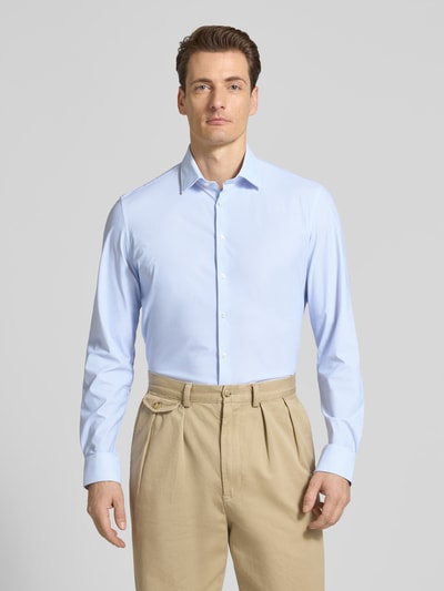 Männermodel trägt Slim Fit Business-Hemd mit Kentkragen von Jake*s, hellblauer Elastischer-Material-Mix, durchgehende Knopfleiste, Sportmanschetten, Ganzkörperansicht von vorne.