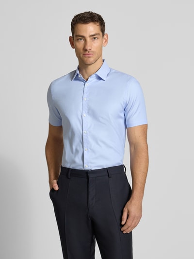 Männermodel trägt Slim Fit Business-Hemd aus Baumwolle mit Kentkragen von Jake*s in Hellblau, Knopfleiste, Ganzkörperansicht von vorne.