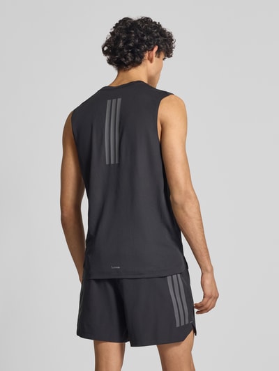 Männermodel trägt Regular Fit Sport Tank Top mit Label Print von adidas Training, schwarz, feines Strukturmuster, breite Träger, Ganzkörperansicht Rückansicht.