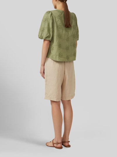 Frauenmodel trägt Regular Fit Kurzarmbluse aus reiner Baumwolle von s.Oliver RED LABEL in Hellgrün, luftige Textur, Ganzkörperansicht Rückansicht.