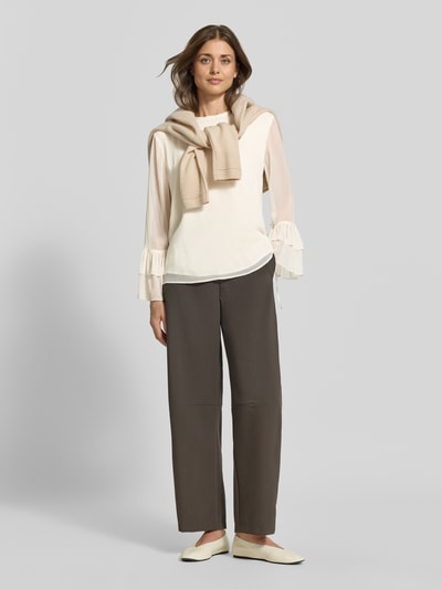 Frauenmodel trägt Bluse mit Volant-Ärmeln von COMMA in Creme, lockere Passform, Rundhalsausschnitt, Ganzkörperansicht von vorne.