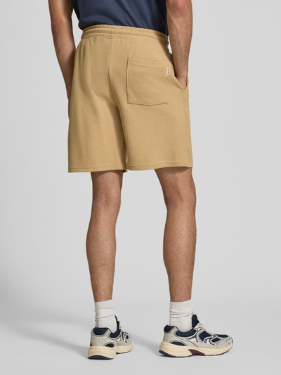 Männermodel trägt Shorts aus Baumwoll-Mix mit Strukturmuster Modell 'KNOX' von Redefined Rebel, beige, Relaxed Fit, Ganzkörperansicht Rückansicht.