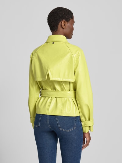 Frauenmodel trägt Jacke mit Gürtel und Ärmelriegeln von Marc Cain in Gelb, strukturierte Oberfläche, Rückenlänge 58 cm, Ganzkörperansicht Rückansicht