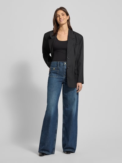 Frauenmodel trägt High-Rise Jeans aus reiner Baumwolle Modell 'DNM MINE 70 S WIDE LEG HW' von Tommy Hilfiger in Denim-Optik, Wide-Leg-Passform, High-Waist-Stil, Label-Patch, Logo-Stitching, Gürtelschlaufen, Kontrastnähte, Knopf und verdeckter Reißverschluss, Eingrifftaschen und Gesäßtaschen, Ganzkörperansicht von vorne.