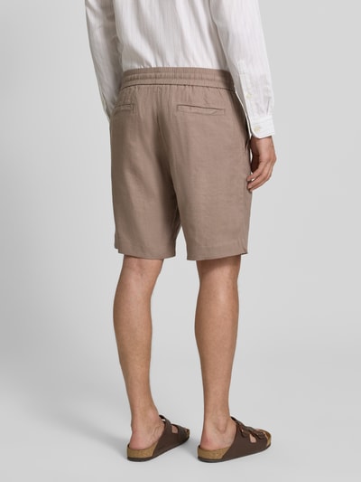 Mężczyzna nosi Straight Fit Chinoshorts aus Leinen-Lyocell-Mix Modell 'CINO' od HUGO, gładka tekstura, kieszenie boczne i z tyłu, elastyczny pas, flammgarn, kolor beżowy, widok na całe ciało z tyłu.
