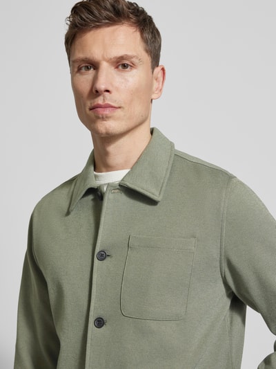 Męskimodel nosi Relaxed Fit Hemdjacke mit Brusttasche von Lindbergh, mieszanka materiałów z dodatkiem wiskozy, wykładany kołnierz, brustasza, listwa guzikowa, długość tyłu w rozmiarze M 69 cm, zbliżenie na górną część tułowia