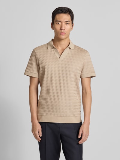 Męskimodel nosi Koszulkę polo z prążkowanymi wykończeniami Model 'Cleison' od JOOP! Collection, bawełna, krój regular fit, beżowy, kołnierzyk polo, dekolt w serek, długość tyłu 69 cm dla rozmiaru M, gładka faktura, całkowity widok z przodu.