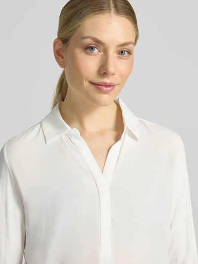 Kobiece model prezentuje bluzkę z długim rękawem Regular Fit Langarmbluse mit Hemdblusenkragen Modell 'Frera' od OPUS w kolorze białym, gładka tekstura, zbliżenie na górną część ciała.