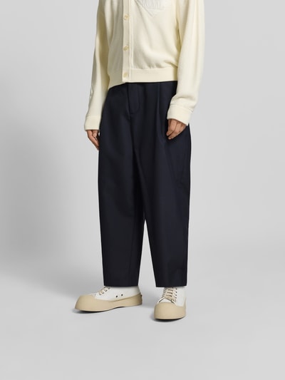 Männermodel trägt Straight Fit Stoffhose mit Bundfalten von MAISON KITSUNÉ in Dunkelblau, Reine Baumwolle, Nahaufnahme Unterkörper. Innenbeinlänge 63 cm, Bundweite 44 cm, verkürzte Passform, Haken- und Reißverschluss.