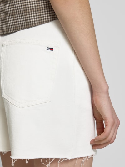 Vrouwenmodel draagt Mom-Fit Jeansshorts aus Baumwoll-Mix van Tommy Jeans in uniwit met label patch, 5-pocket, twill; detailopname rug.