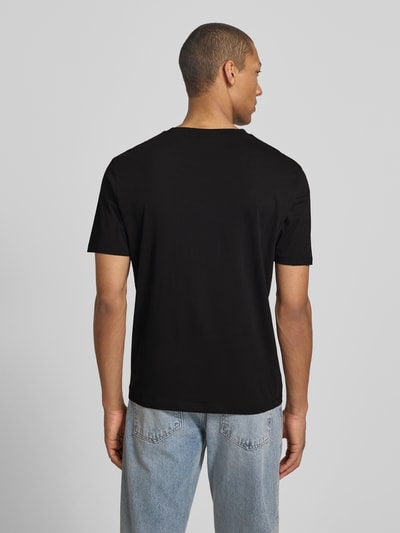 Männermodel trägt Relaxed Fit T-Shirt aus reiner Baumwolle Modell 'DOSTINO' von HUGO in Schwarz, unifarben, Kurzarm, Rückansicht.