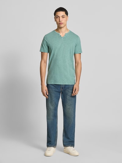 Männermodel trägt T-Shirt aus Baumwolle Modell 'SPLIT' von Jack & Jones in Mintgrün mit V-Ausschnitt, gerader Schnitt, Ganzkörperansicht von vorne.