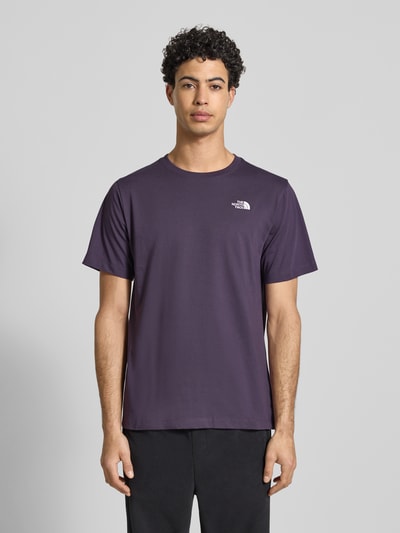 Mężczyzna nosi Regular Fit T-Shirt aus Baumwoll-Mix Modell 'EVOLUTION' von The North Face, ciemnofioletowy, okrągły dekolt, nadruk z logo, krój regular fit, bawełniany materiał, długość tyłu w rozmiarze M: 71 cm, całkowity widok z przodu.