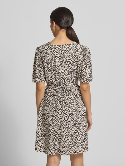 Frauenmodel trägt Minikleid aus Viskose mit kurzer Knopfleiste Modell 'GRACE' von Vila, taillierter Schnitt, Bindegürtel, Rückansicht Ganzkörperansicht.