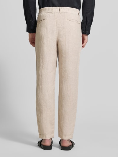 Mannenmodel draagt Tapered Fit Leinenhose mit Eingrifftaschen van MCNEAL in zuiver linnen, steekzakken, paspelzakken achter, kleur beige, ganzkörperansicht rückansicht.