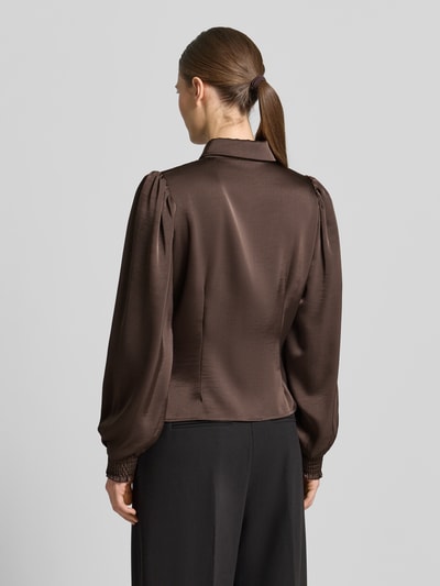 Modelka nosi Regular Fit Hemdbluse mit Raffungen Modell 'Fransala' od Neo Noir, brązowy materiał z połyskiem, długa rękaw, widok z tyłu, krój regular fit, dekolt koszulowy, elastyczne mankiety, długość tyłu 55 cm, długość rękawa 65 cm. Ganzkörperansicht Rückansicht.