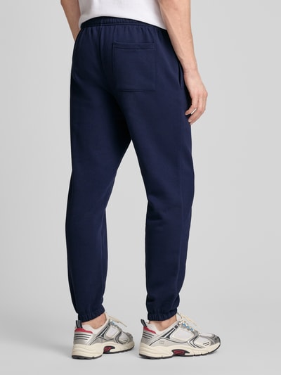 Männermodel trägt Sweatpants mit Logo und elastischem Bund von GAP in Dunkelblau, Baumwoll-Mix, Regular-Fit, Ganzkörperansicht Rückansicht.