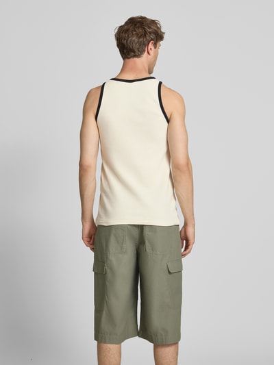 Männermodel trägt Slim Fit Top mit Rundhalsausschnitt von KARL KANI aus Reine Baumwolle mit Logo-Stitching und Strukturmuster, Ganzkörperansicht Rückansicht.