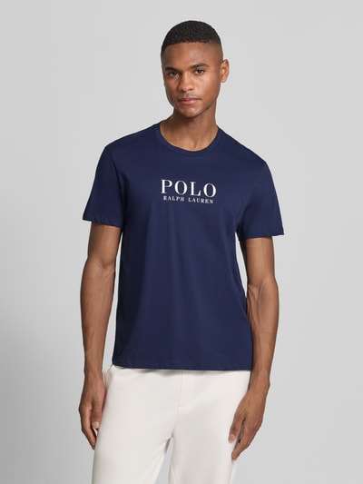 Männermodel trägt Regular Fit Pyjama-Oberteil aus reiner Baumwolle Modell 'CREW-SLEEP-TOP' von Polo Ralph Lauren Underwear in Optik: Unifarben, Label-Print und Logo-Stitching, mit Crew Neck und Kurzarm, Ganzkörperansicht von vorne.