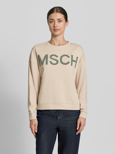Modelka kobieca ma na sobie Sweatshirt mit Label-Stitching Modell 'Mela Briena' od MSCH Copenhagen, beżowy, luźny krój, bawełniany miks, przód, ujęcie całej sylwetki z przodu.
