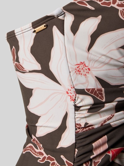 Frauenmodel trägt Badeanzug mit Neckholder Modell 'Camolo' von Barts im Material-Mix mit Stretch-Anteil, florales Muster, Knoten-Detail, V-Ausschnitt, Nahaufnahme Oberkörper.