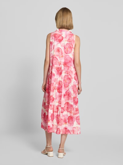 Frauenmodel trägt Midikleid aus Viskose Modell 'Vi44vii' von ZABAIONE im Allover-Look mit rosa und roten Farbtönen, Ganzkörperansicht Rückansicht.