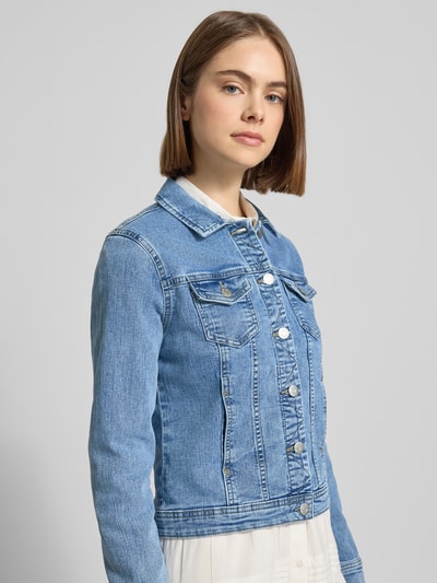 Frauenmodel trägt Regular Fit Jeansjacke aus Baumwoll-Mix Modell 'Wonder' von Only in heller Denim-Optik mit Brusttaschen, Knopfleiste, Umlegekragen und sichtbaren Nähten, Nahaufnahme Oberkörper.