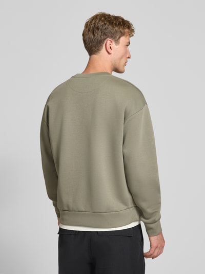 Męski model nosi Regular Fit Sweatshirt mit Baumwoll-Anteil od JACK & JONES, mieszanka bawełny, okrągły dekolt, długi rękaw, długość tyłu 65 cm, długość rękawów 59 cm, kolor jasnoszary, gładka tekstura, elastyczne wykończenia, widok całej sylwetki z tyłu.