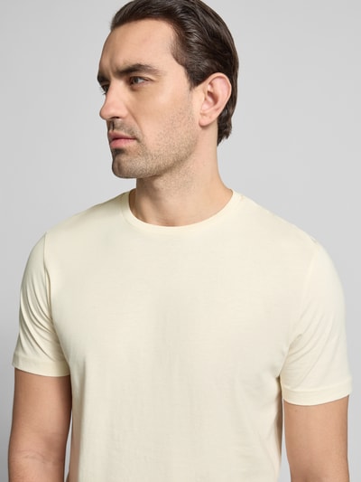 Männermodel trägt T-Shirt mit Rundhalsausschnitt von Christian Berg Men in Creme, Regular Fit, reine Baumwolle, Nahaufnahme Oberkörper.