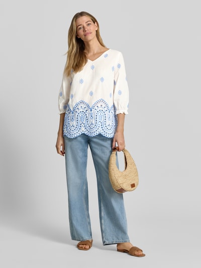 Frauenmodel trägt Relaxed Fit Bluse mit Lochstitching in Paisley-Optik von More & More, Baumwoll-Mix, V-Ausschnitt, 3/4-Arm, Ganzkörperansicht von vorne. Rückenlänge bei Größe 36: 66 cm; Ärmellänge bei Größe 36: 45 cm.