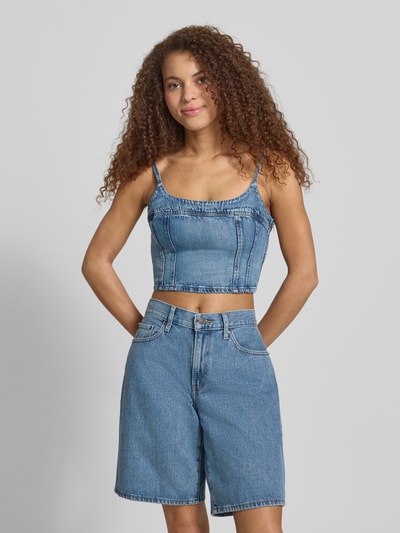 Modelka kobieca nosi Slim Fit Crop Top aus reiner Baumwolle Modell 'JADINE' od Levi's®, denimowy wygląd, krój slim fit, label, ozdobne szwy, boczny zamek, kwadratowy dekolt, regulowane ramiączka, bez rękawów, bawełna; widok całej sylwetki z przodu.