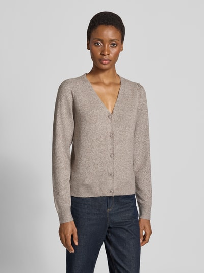 Vrouwenmodel draagt Regular fit gebreid jack met v-hals model 'DOFFY' van VERO MODA, beige tint, grof gebreide textuur, volledige lichaamsvooraanzicht.