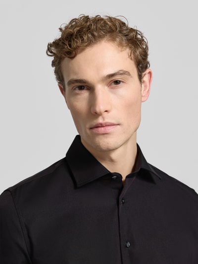 Männermodel draagt Slim Fit Business-Hemd uit puur katoen van Seidensticker in zwart met Kentkraag en doorlopende knoopsluiting, Nahaufnahme Oberkörper.