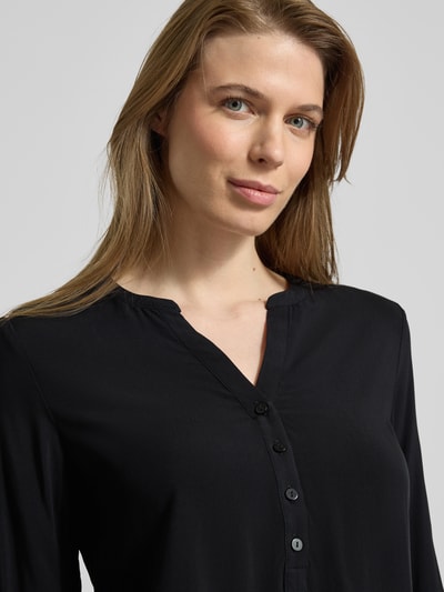 Kobiece modelka nosi Regular Fit Bluzka z czystej wiskozy z dekoltem z lamówką od Christian Berg Woman, listwa guzikowa, z długim rękawem, długość tyłu w rozmiarze 36: 64 cm, długość rękawów w rozmiarze 36: 60 cm, czarna, gładka faktura, zbliżenie górnej części ciała.